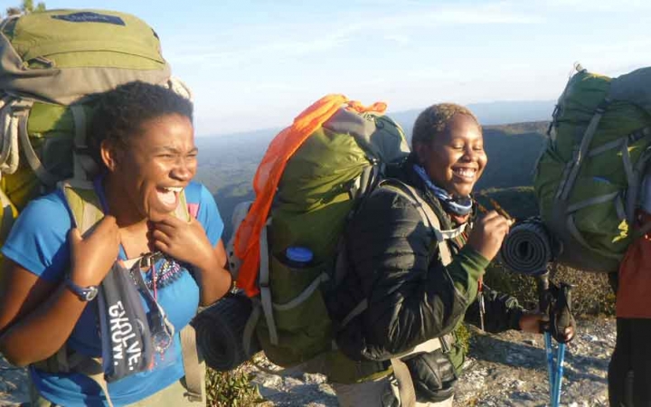 a group of gap year students laugh while on a summit overlooking the blue ridge mountains in north carolina